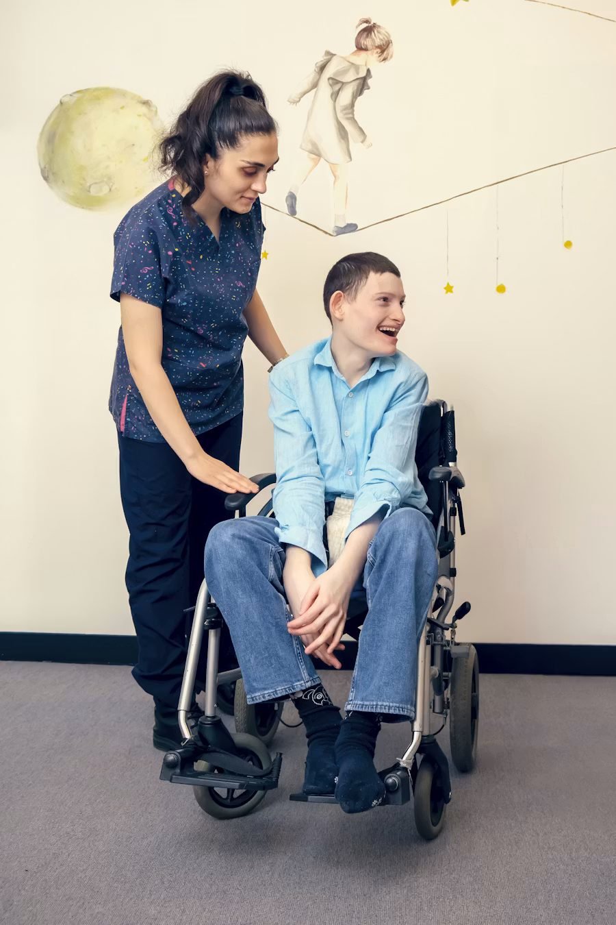 Accessable Care support worker chatting with a participant in his wheelchair in a therapy room